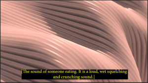 A screenshot of a section from the short film clip. There is pink digitally sculpted landscape with peaks resembling digital sand dunes, with the appearance of identical grooves over the landscape. There is a caption in yellow text on a back background at the bottom of the screen which reads “[The sound of someone eating. It is a loud, wet squelching and crunching sound.]”