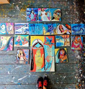 photograph of 16 paintings on the floor in the studio.