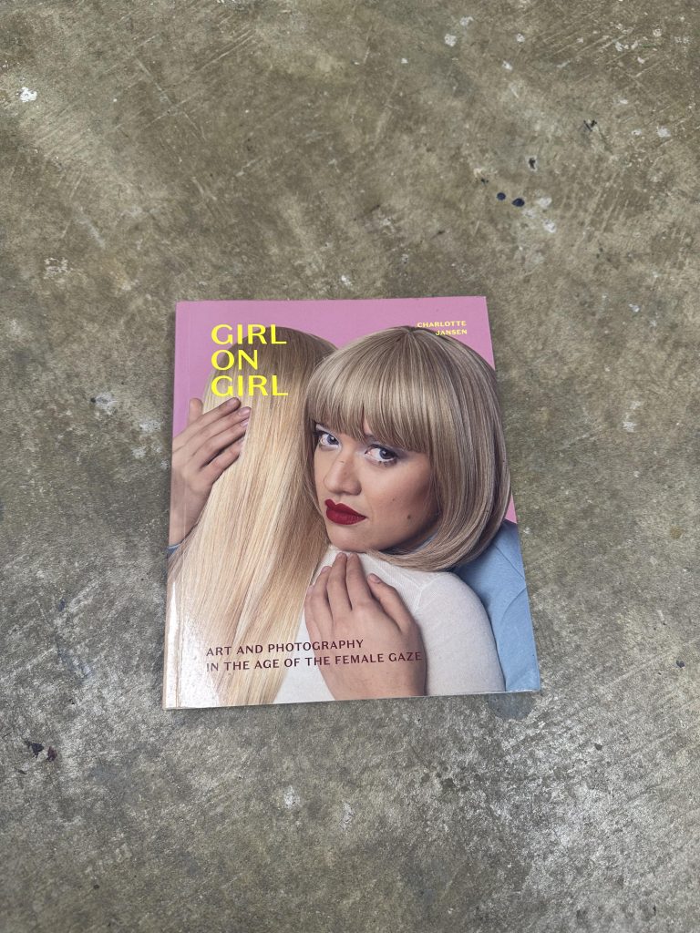girl on girl book by Charlotte Jenson 
the book is a paper back with a pink cover with two blonde female representing women embracing, one woman is looking directly at the viewer while the other is facing away from the viewer