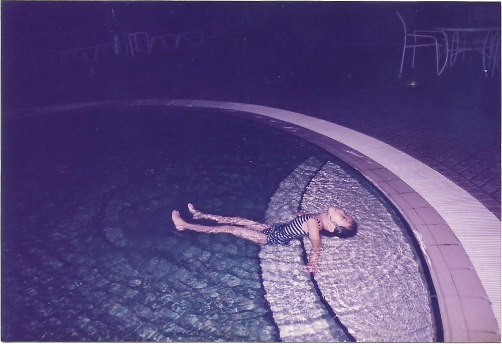 Digitised photograph of an Asian child in a swimming pool.