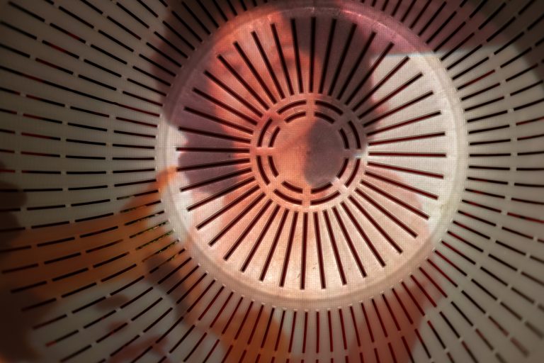 Colour landscape photograph of a 20s woman portrait projected on the colander.
